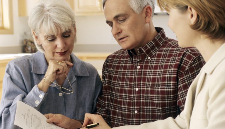 Elderly couple meeting with an agent to sign a will