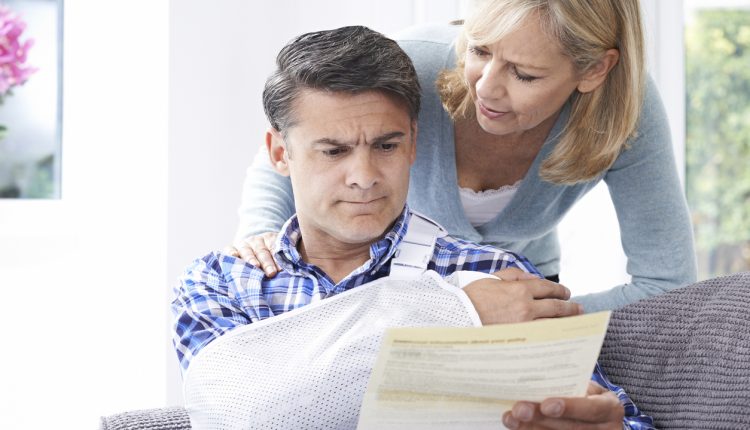 Couple reading insurance letter about husband's injury