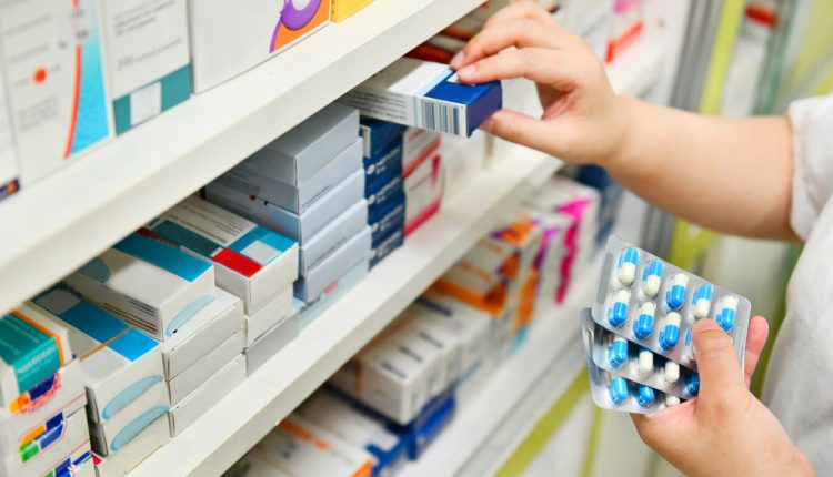Pharmacist taking medicine off a shelf