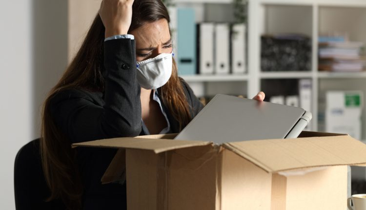 Sacked employee with mask packing her belongings