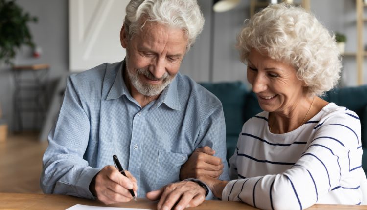 Older couple signing a legal document