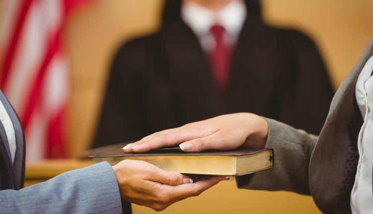 Witness swearing on the Bible in a courtroom