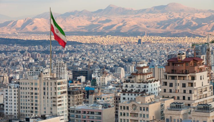 Iranian flag above the Tehran skyline