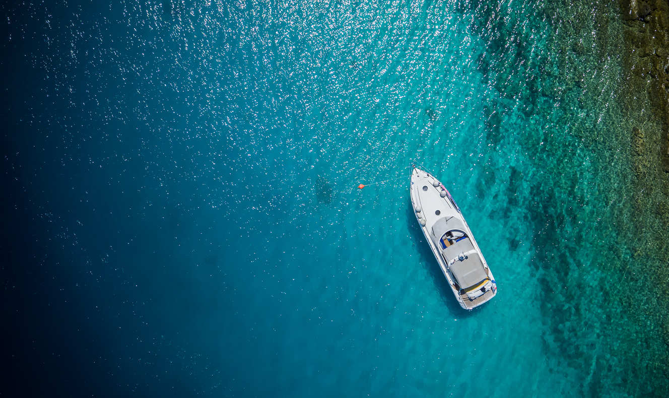 Luxury small yacht anchoring in shallow water