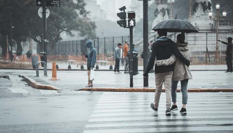 Pedestrians crossing road in rain