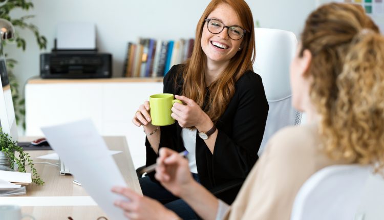 Female business professionals having coffee in office