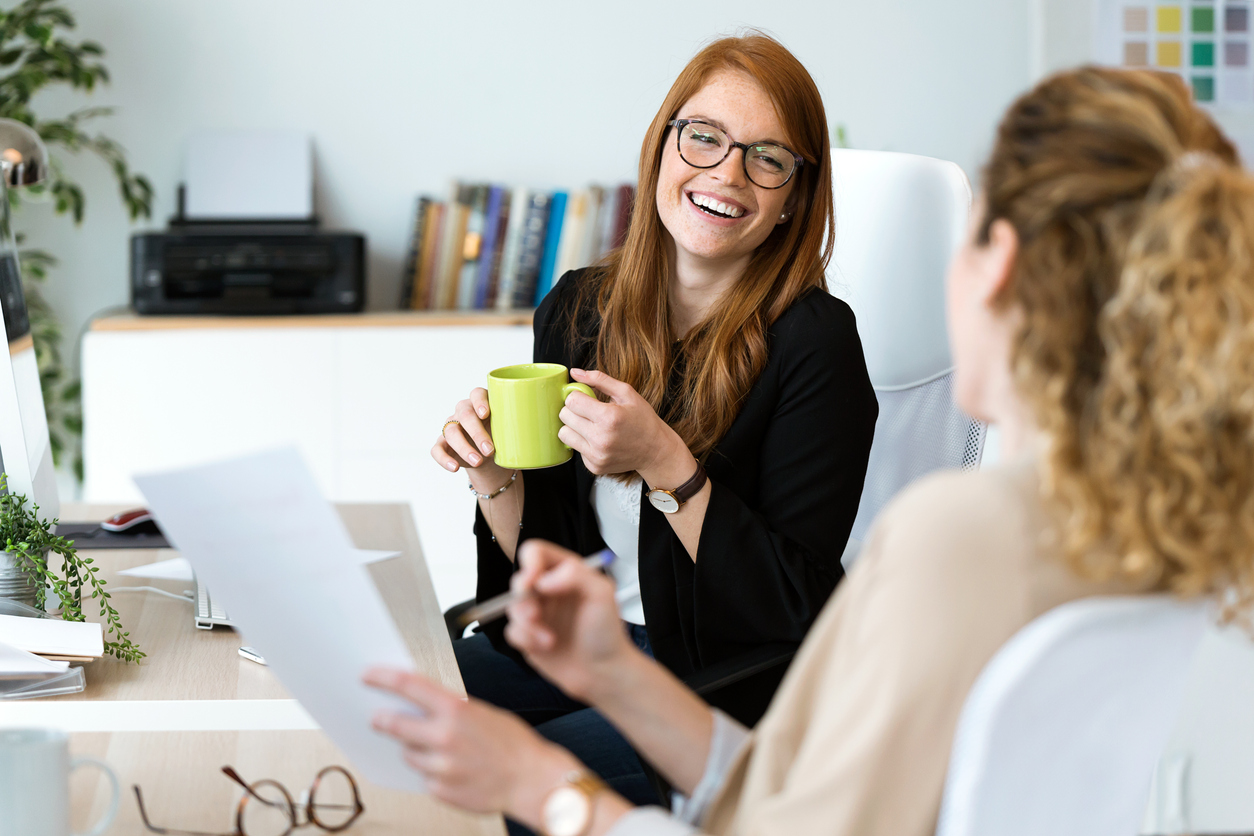 Female business professionals having coffee in office