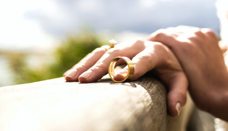 Wedding ring leaving finger, symbolising divorce