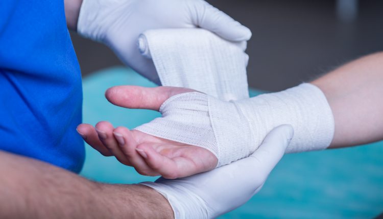 Medical professional bandaging hand