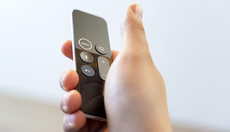 Hand using Apple TV remote
