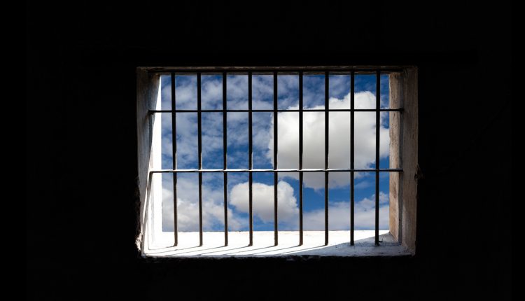Blue sky outside jail bars