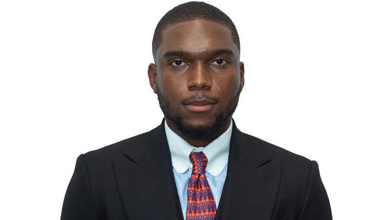 Ghanaian ADR specialist wearing a business suit in front of a white background.