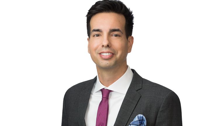 California employment law expert in suit standing in front of white background.