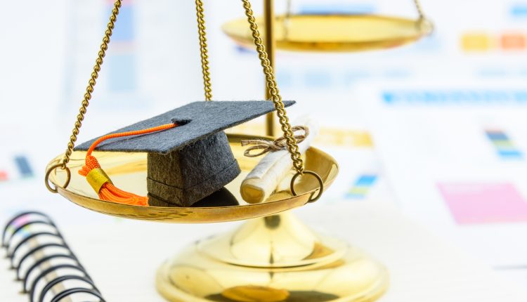 Graduate study abroad program concept : Graduation cap on a balance scale of justice and a certificate / diploma. Graduate study abroad program is a program that accept students from foreign countries