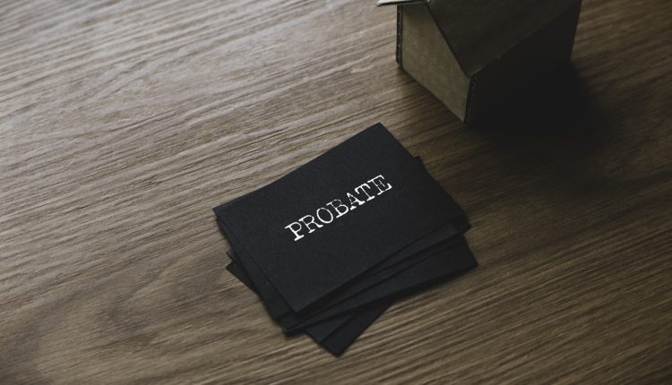 Selective focus of a stack of black paper written with Probate and small cardboard house.