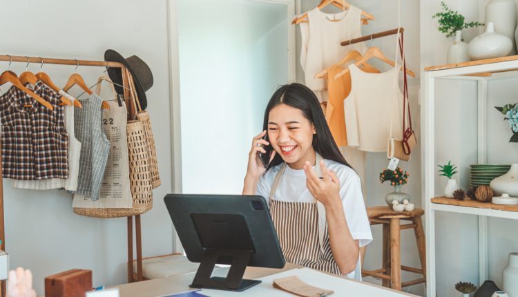Small business owner talking on the phone with customers in a small shop. and check orders, check the orders that customers order from online retailers - online shopping
