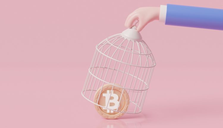 Hand catching bitcoin with birdcage, government try to regulate bitcoin and cryptocurrency, policy for collecting taxes on crypto trading concept.