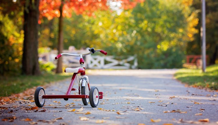Tricycle in the park on sunset, autumn time, children in the park, enjoying warn autumn day