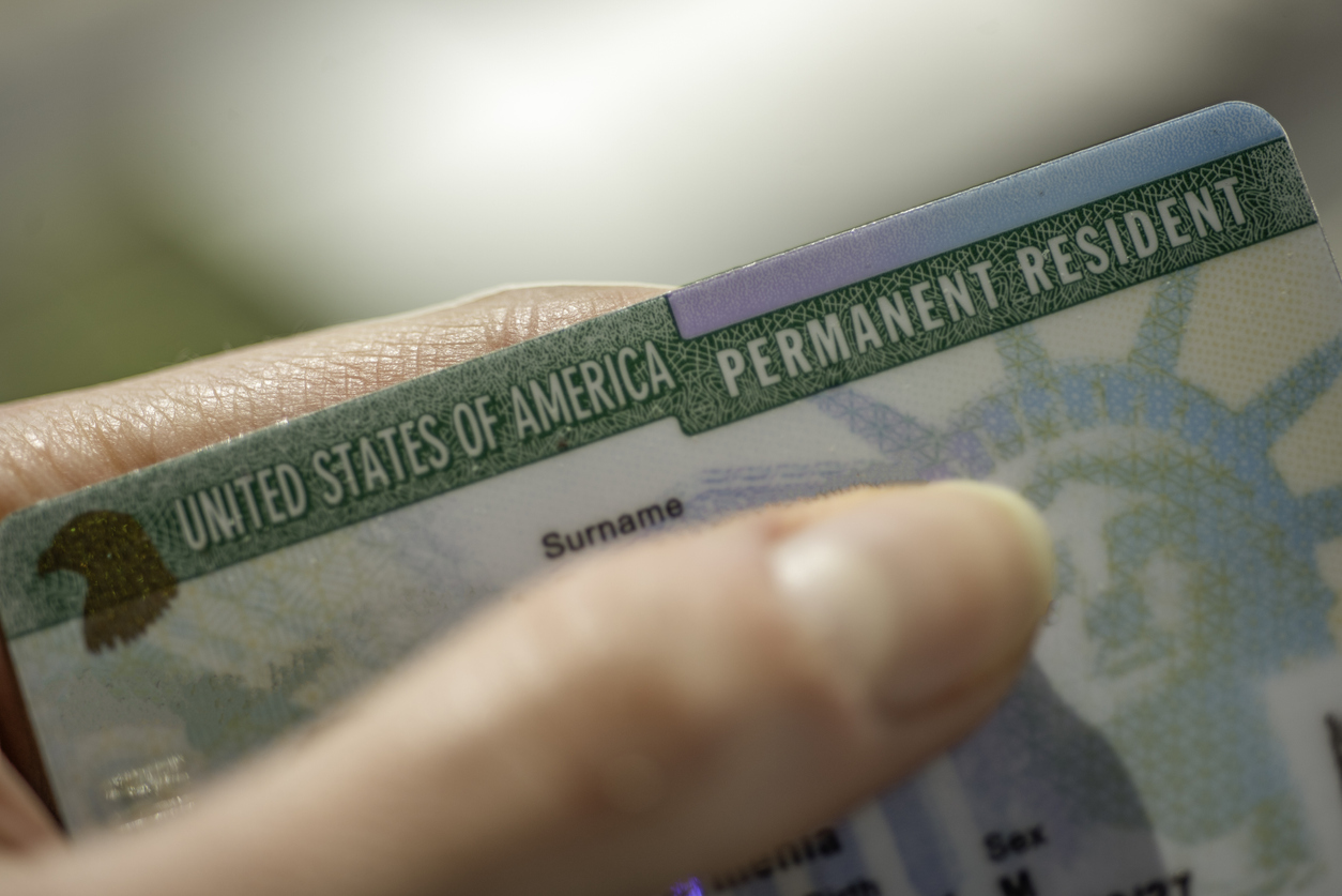 Close up view of Permanent resident card (Green) card of USA on blurred background.
