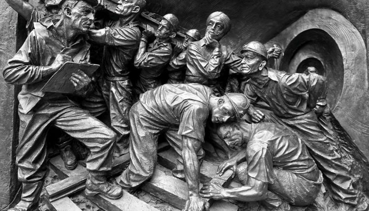 A statue of workers and a workers' injury.