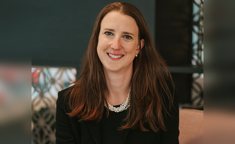 Female lawyer standing in front of a window.