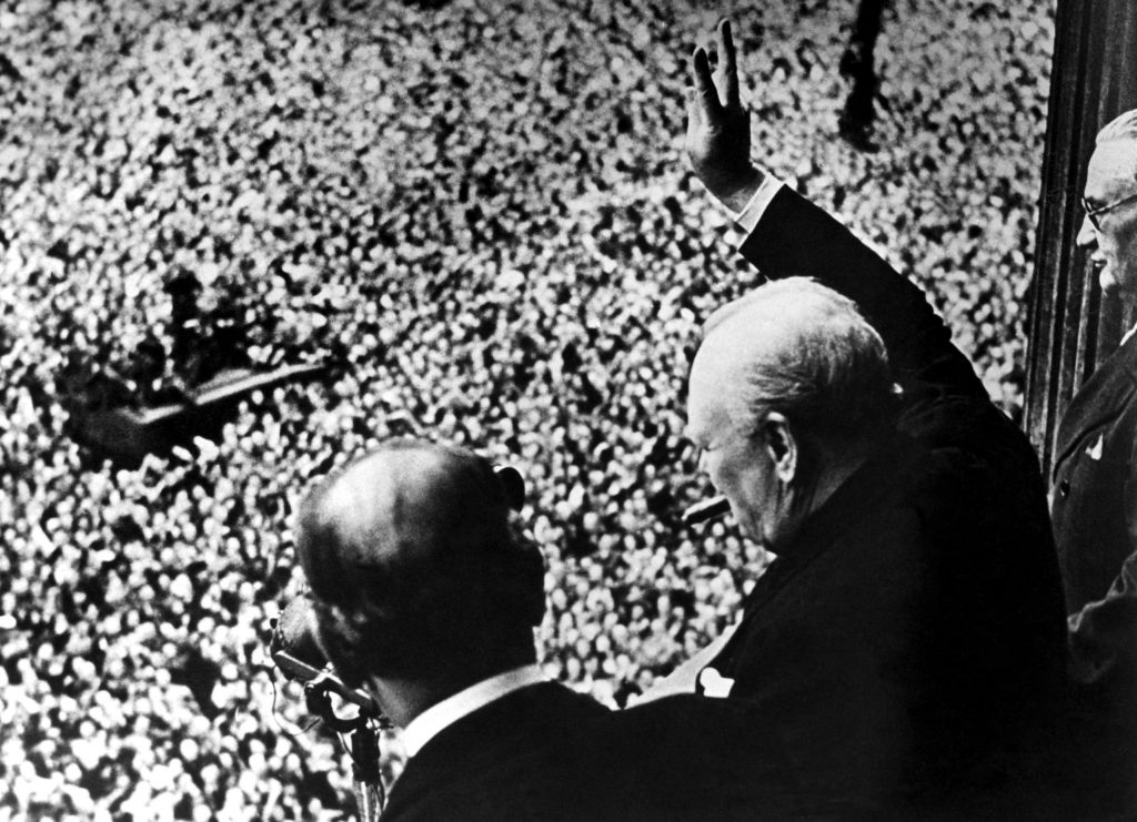 A nation’s hero: Winston Churchill waves to cheering crowds from the balcony of the Ministry of Health on VE Day, as Britain celebrates victory and the end of war in Europe.
