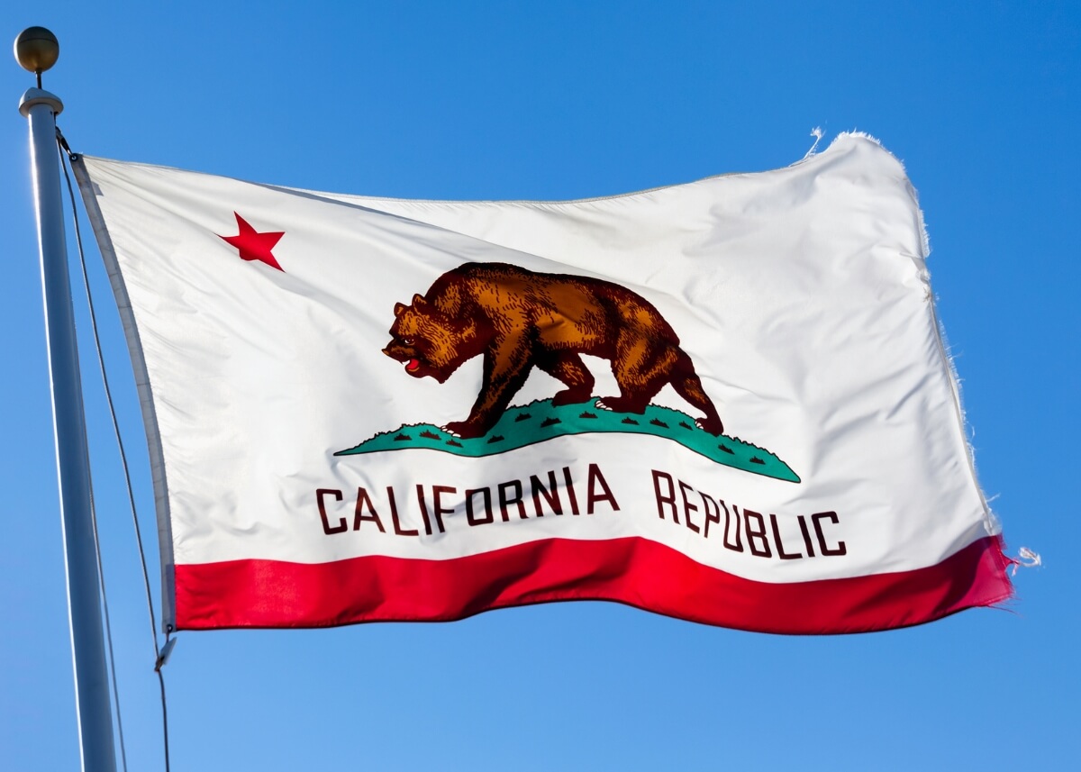 California state flag waving on a flagpole with clear blue sky background