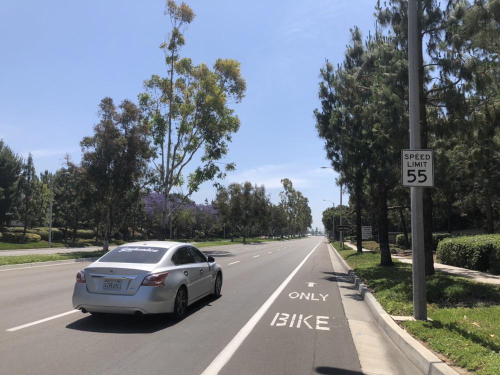 A bike lane in California with cars passing nearby