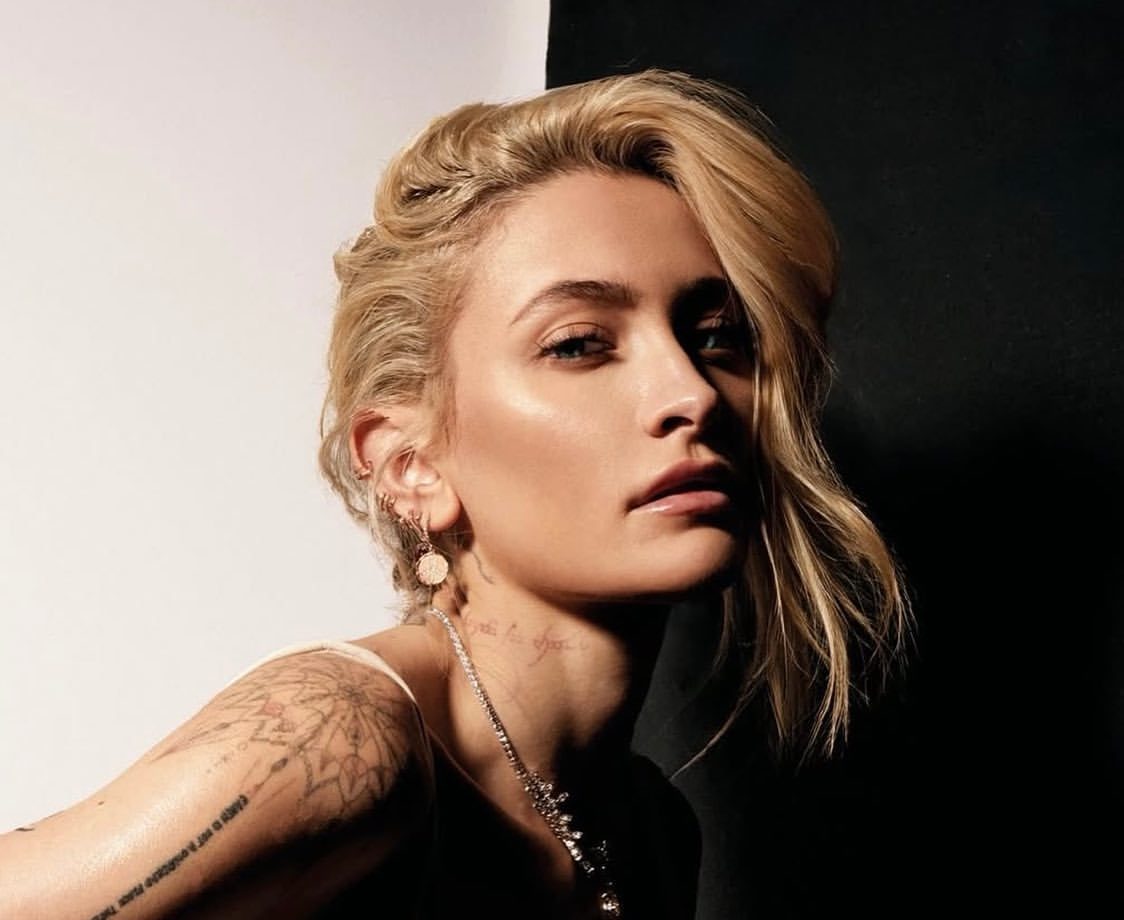Paris Jackson photographed in studio lighting, wearing a cream dress and jewelry.