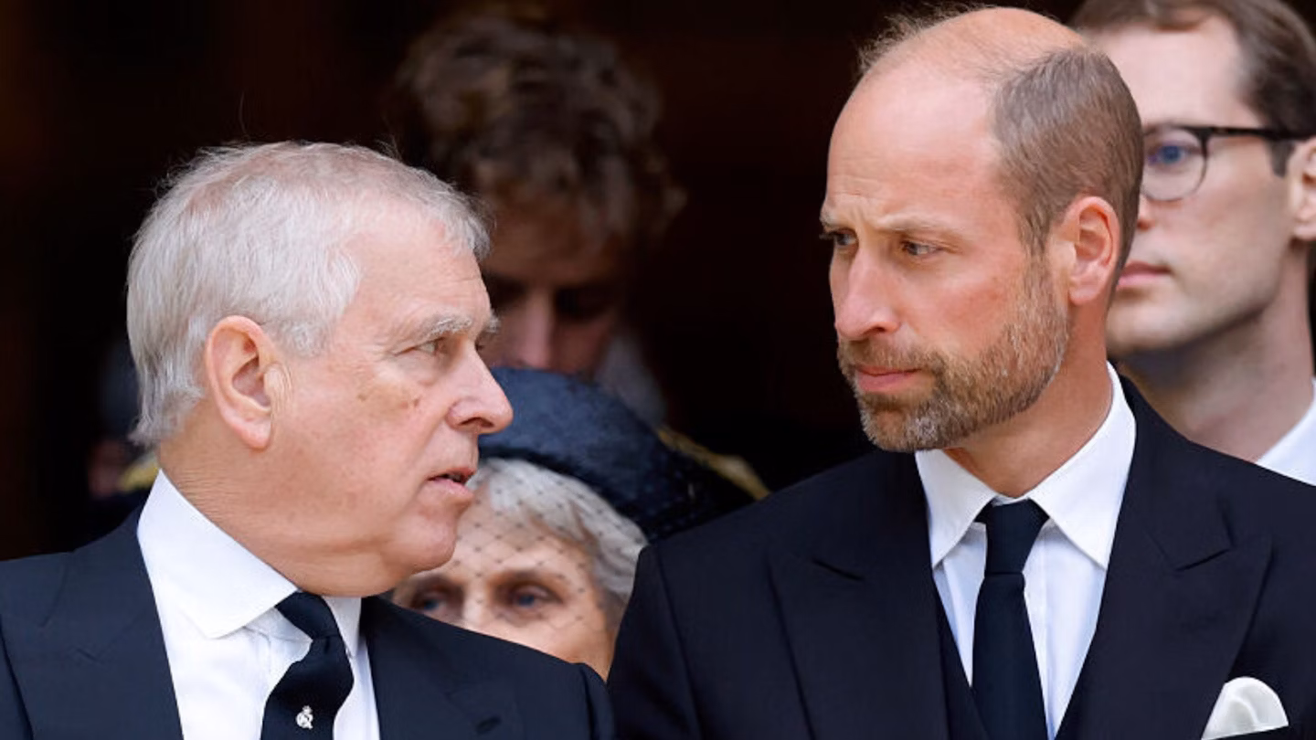Two men dressed in formal black suits speaking at a public event.