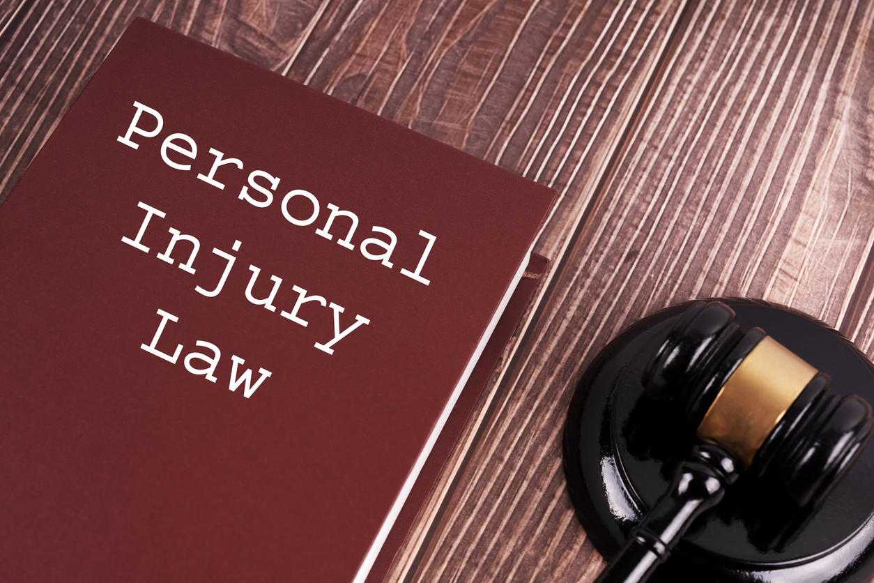 personal injury law written on a book with judge gavel on wooden table background.
