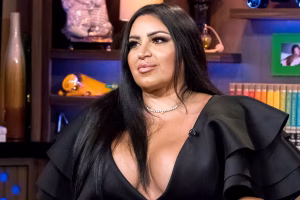 Mercedes “MJ” Javid appears during a television interview, wearing a black dress with ruffled sleeves and a diamond necklace.