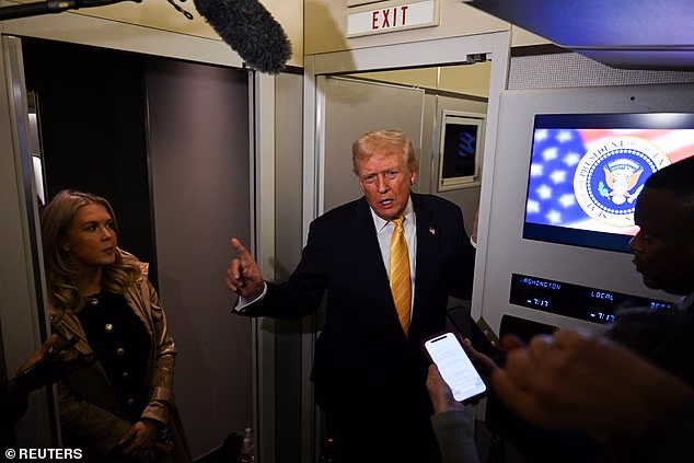 Donald Trump speaks to reporters aboard Air Force One, gesturing during a tense exchange as journalists record his comments.
