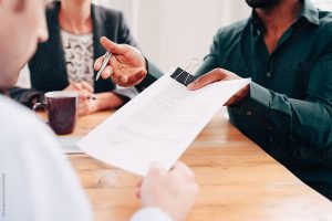 Couple reviewing legal documents with a professional during a discussion about family agreements and long-term planning.