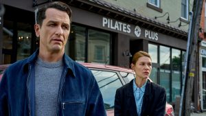 Matthew Rhys and Claire Danes stand tensely outside a Pilates studio in a scene from Netflix’s psychological thriller The Beast in Me.