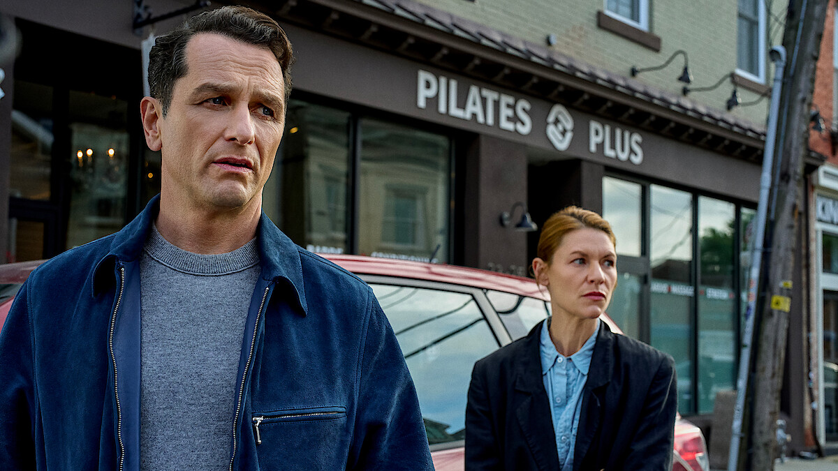 Matthew Rhys and Claire Danes stand tensely outside a Pilates studio in a scene from Netflix’s psychological thriller The Beast in Me.