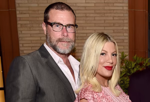 Tori Spelling and Dean McDermott walking together amid reports of major tax debt revealed in their divorce settlement.
