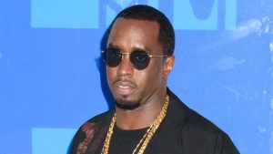 Sean “Diddy” Combs wearing sunglasses and a gold chain at a public event.
