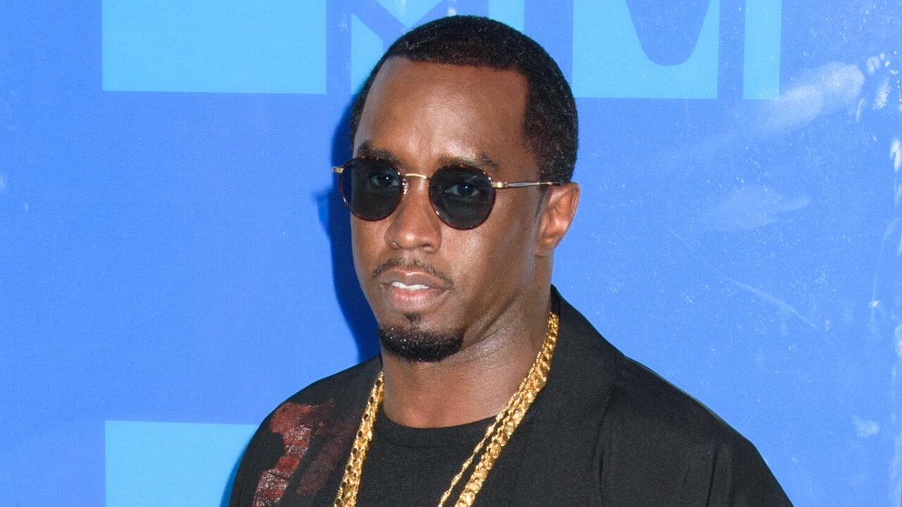 Sean “Diddy” Combs wearing sunglasses and a gold chain at a public event.