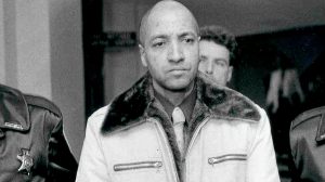 George Emil Banks in handcuffs escorted by law enforcement officers after his arrest in Pennsylvania in 1982.