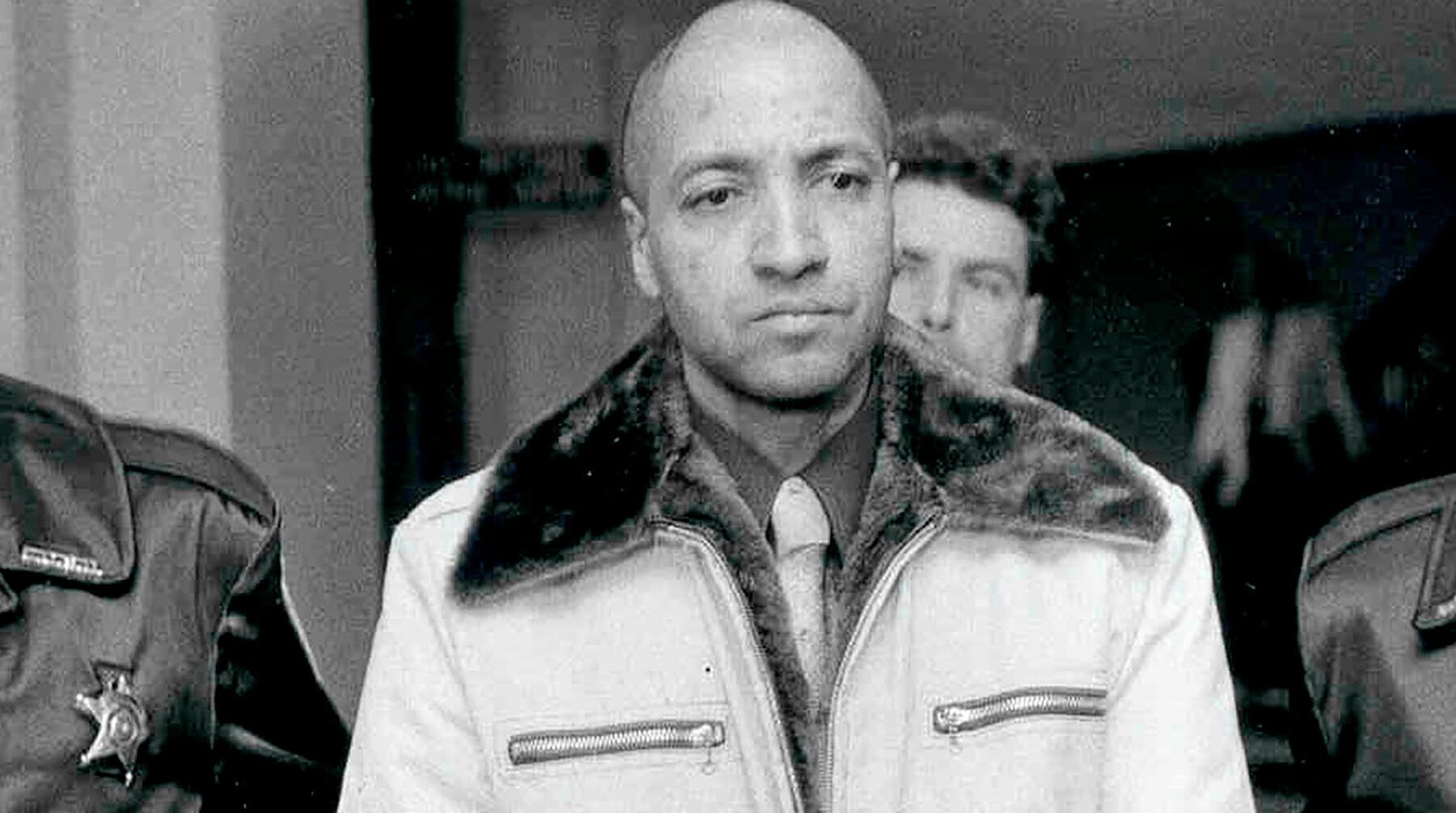 George Emil Banks in handcuffs escorted by law enforcement officers after his arrest in Pennsylvania in 1982.