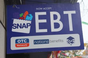 Store sign indicating that SNAP EBT benefits are accepted, featuring the SNAP logo and partner program icons