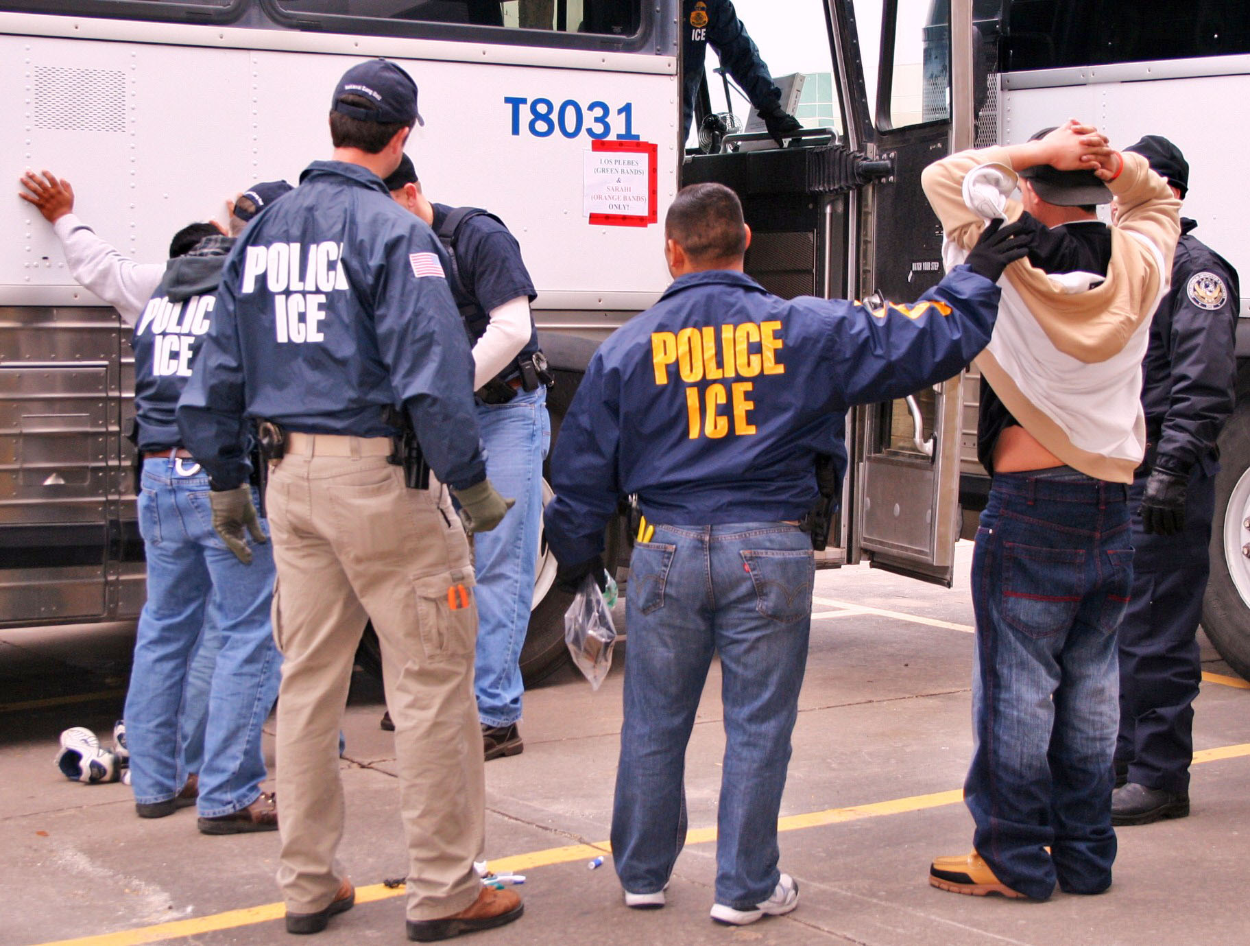 ICE agents detaining an individual during an immigration enforcement operation.