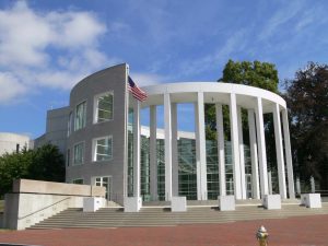 Modern U.S. federal courthouse building with white columns and an American flag at the entrance.