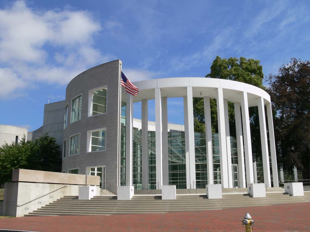 Modern U.S. federal courthouse building with white columns and an American flag at the entrance.