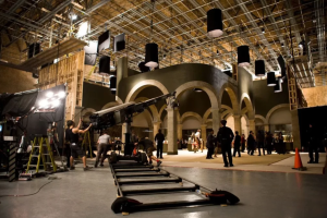 A professional film set with lighting rigs, crew members, and camera equipment, illustrating the complex environment where on-set consent and workplace boundaries matter.