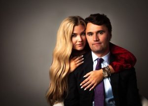 Erika Kirk and her late husband Charlie Kirk posing together in a studio portrait.