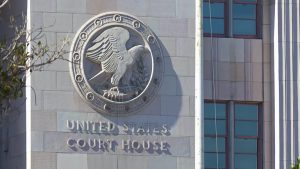 Exterior of a United States courthouse featuring the federal eagle seal on the stone façade