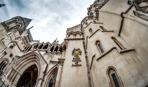 Exterior of the Royal Courts of Justice in London, showing the historic stone facade and crest.