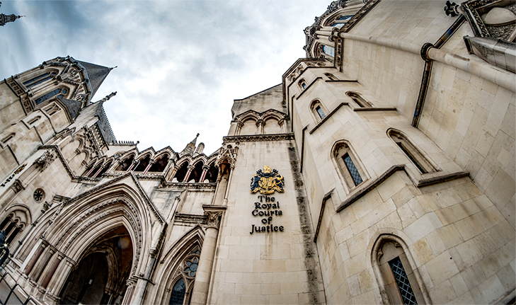 Exterior of the Royal Courts of Justice in London, showing the historic stone facade and crest.